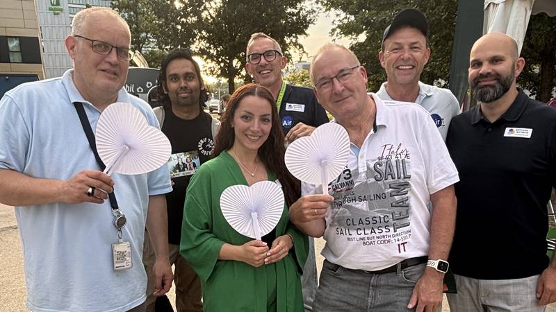 Mitarbeitende von AirIT Services beim Sommerfest mit Fächern in Herzform